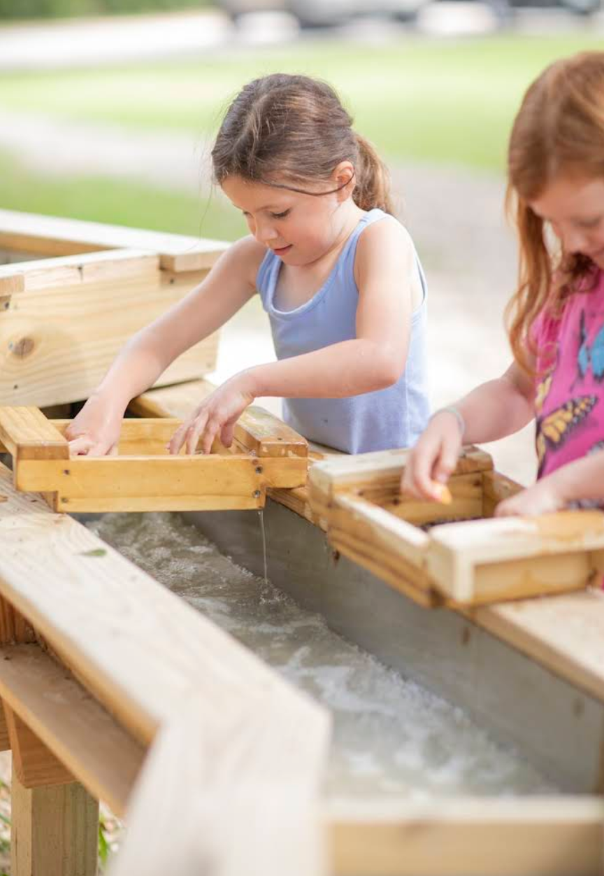 Kids sluicing for gems in the running water