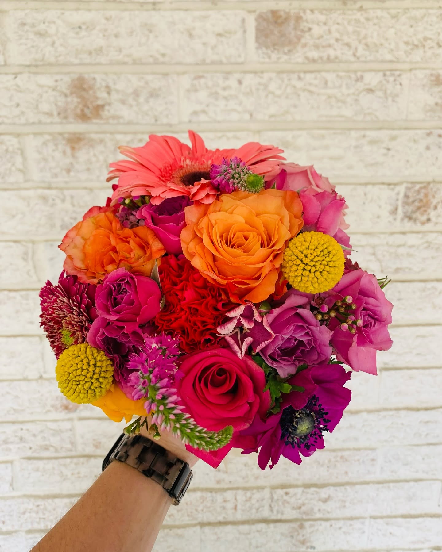 Bright pink and orange bouquet with roses and craspedia