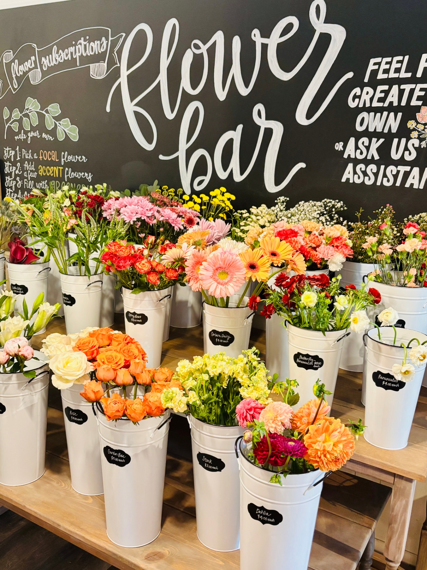 Flower Bar chalkboard sign with buckets of fresh stems
